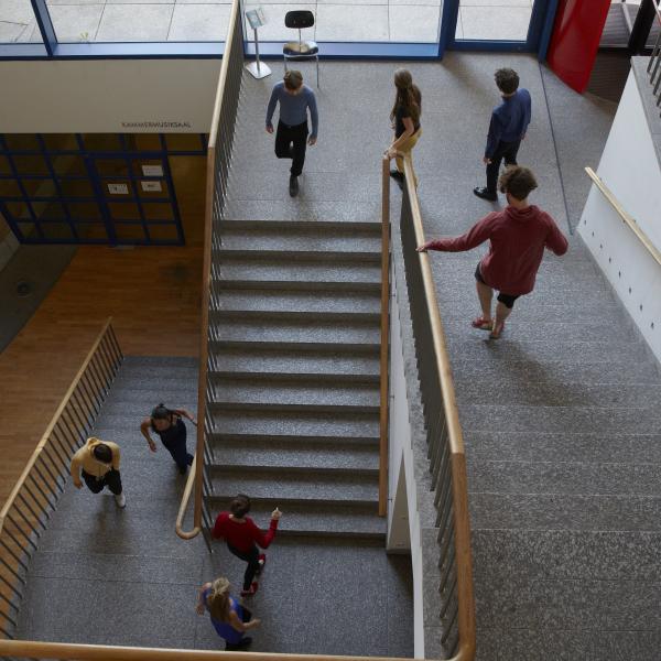 Studierende im Treppenhaus der Hochschule.