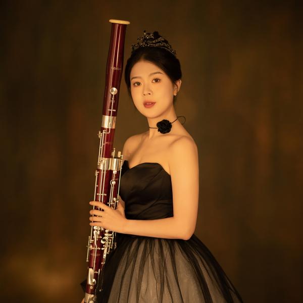 Studentin Elena Guan in einem festlichen Kleid mit ihrem Fagott.