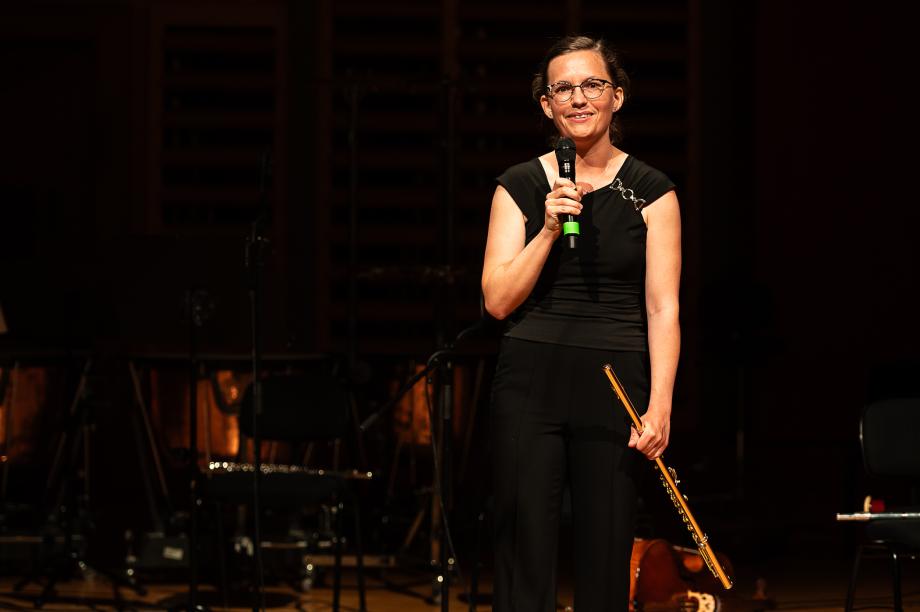 Karolin Schmitt-Weidmann moderierend auf dem Konzertsaalpodium.