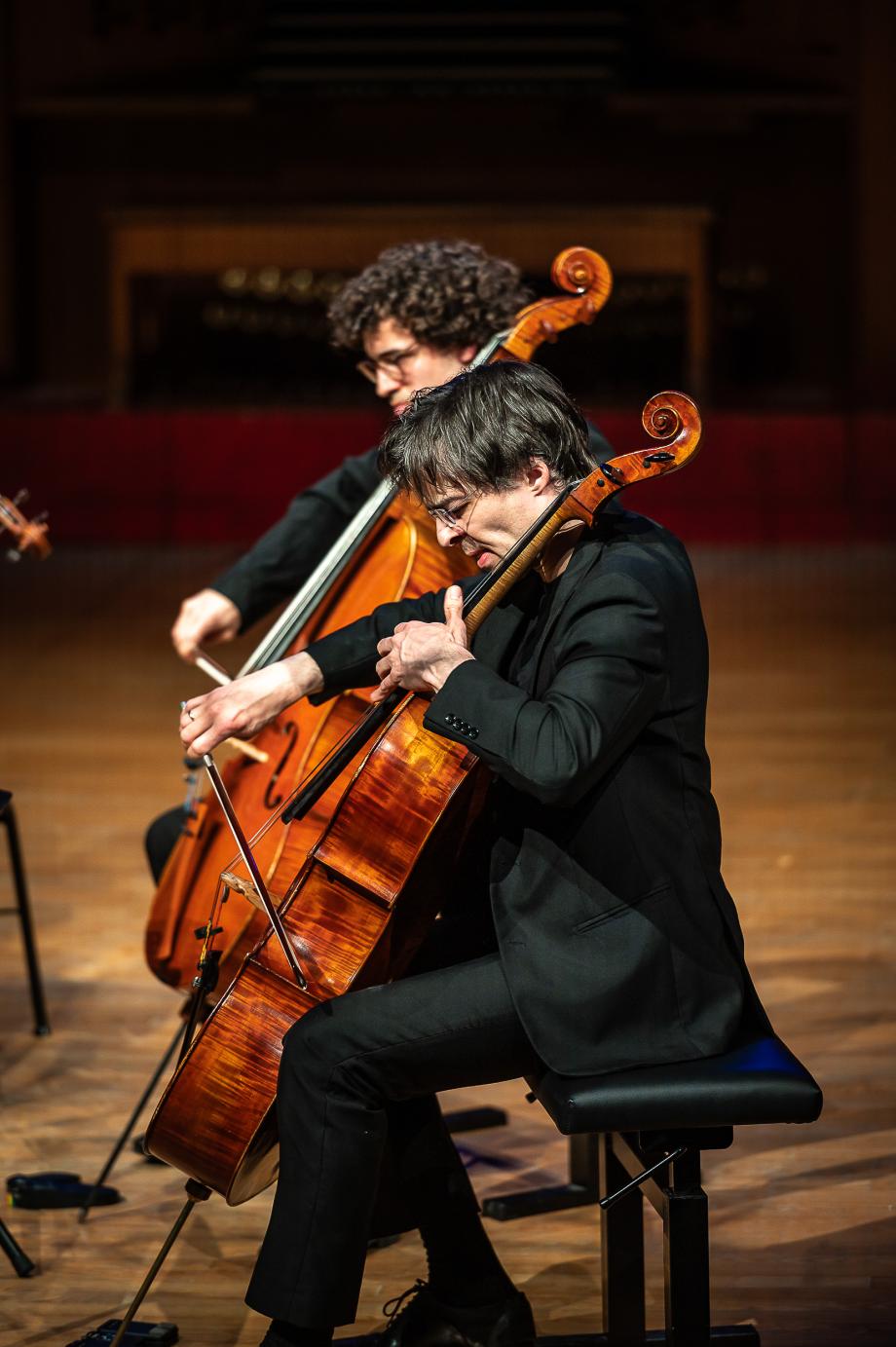Profilansicht des Violoncelloprofessors Tristan Cornut beim gemeinsamen Musizieren mit einem Studierenden seiner Klasse.