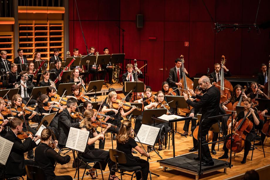 Prof. Rasmus Baumann dirigiert das Hochschulsinfonieorchester im Konzertsaal.