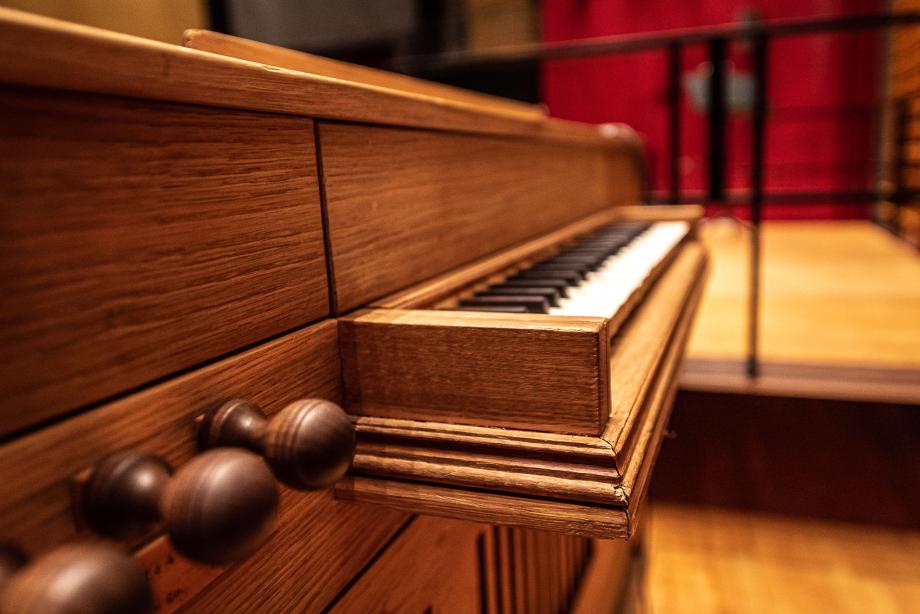Detailaufnahme von links auf die tastutur der Truhenorgel. Die Holzmaserung und die Register sind detailliert zu erkennen.