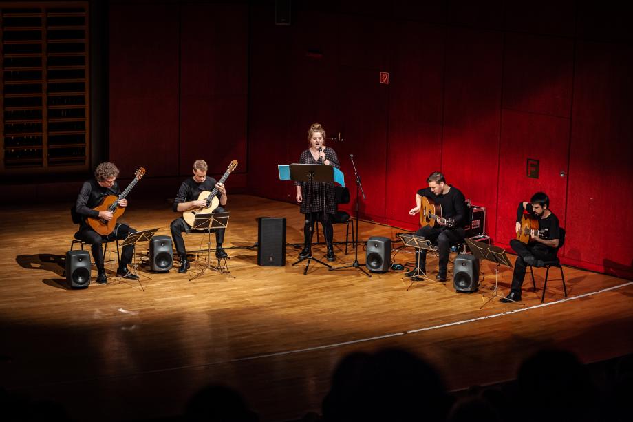 Vier Studierende mit Gitarren und einer Sängerin.