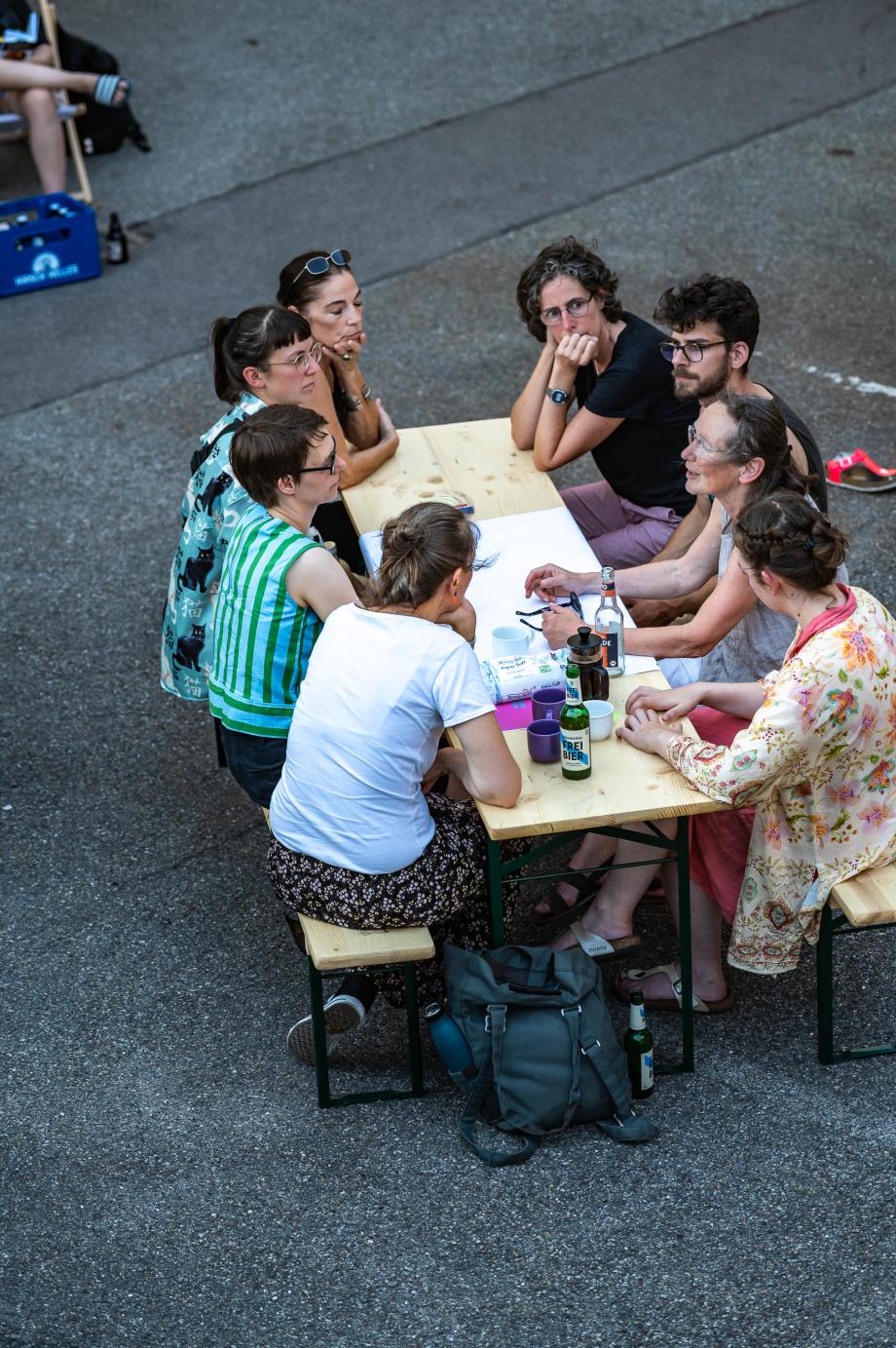 Studierende und Dozent*innen diskutieren im Außenbereich des Maker-Space. 